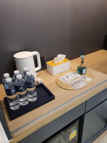 a counter with bottles of water on a table at The Nhorm Hotel Ratchada in Bangkok