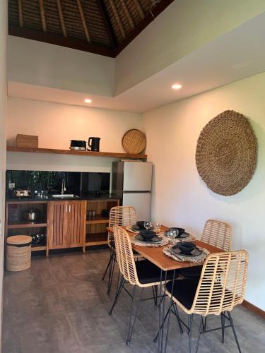 a kitchen with a table with chairs and a refrigerator at La Reserva Villas Bali in Jimbaran