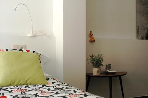 a bedroom with a bed with a green pillow and a table at El Terrat Sobre el Mercat in La Seu d'Urgell