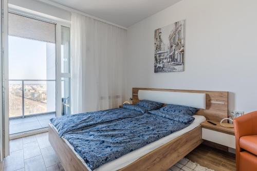 um quarto com uma cama e uma grande janela em Apartament Port em Gdynia