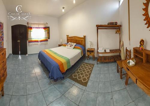 a bedroom with a bed and a table and a mirror at Casa de Alicia Habitación Monte Albán in Oaxaca City