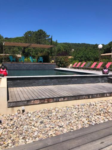 a swimming pool with a person sitting on the rocks at Pleasant private villa Located in a garden of 8000m2 with trees in Porto-Vecchio