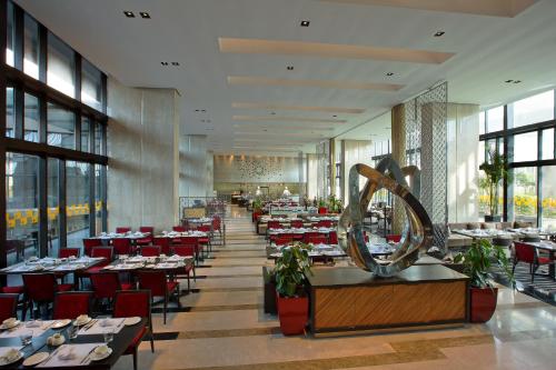 a dining room with tables and red chairs at Novotel Kolkata Hotel and Residences in Kolkata