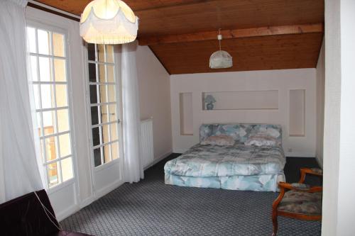 Holiday home Maison de la litiére في Pugny-Chatenod: غرفة نوم بسرير ونوافذ كبيرة