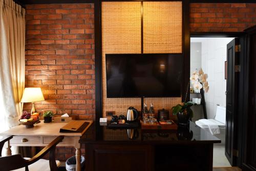 a room with a table and a brick wall at El Barrio Lanna in Chiang Mai