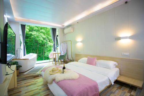 a bedroom with a bed and a tub and a sink at Sure I Do全景山宿 in Yangshuo