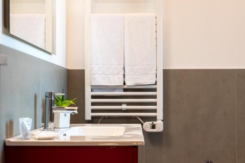 a bathroom with a sink and a mirror with towels at Superior Beach Aparthotel in Lido di Jesolo