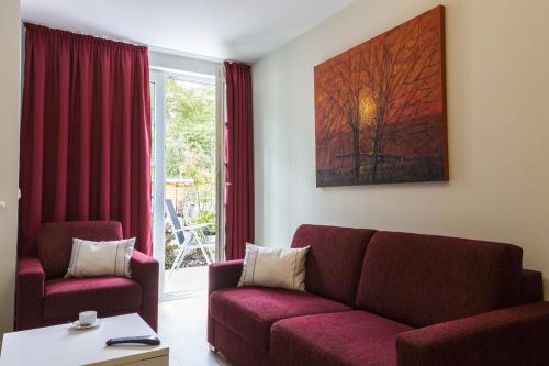 sala de estar con sofá, 2 sillas y ventana en Apartment Residenz am Balmer See Wohnung 44 mit Wellnessbereich, en Balm