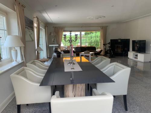 ein Esszimmer mit einem Tisch und weißen Stühlen in der Unterkunft Strandbungalow / Ferienhaus Ostsee in Scharbeutz