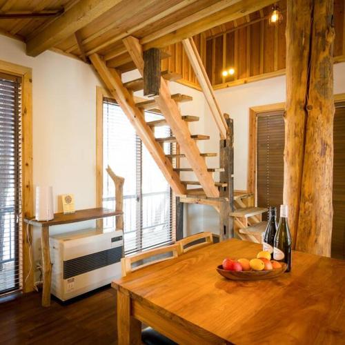 a kitchen with a wooden table with a bowl of fruit at Misorano Chalet in Hakuba