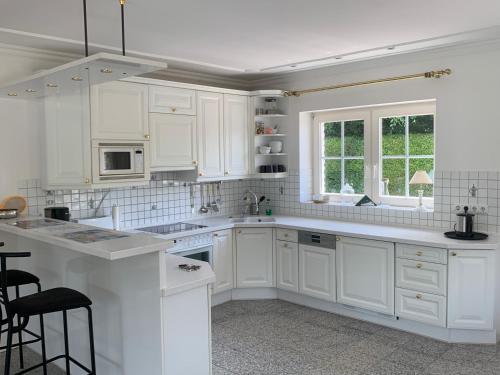 a white kitchen with white cabinets and a sink at Strandbungalow / Ferienhaus Ostsee in Scharbeutz