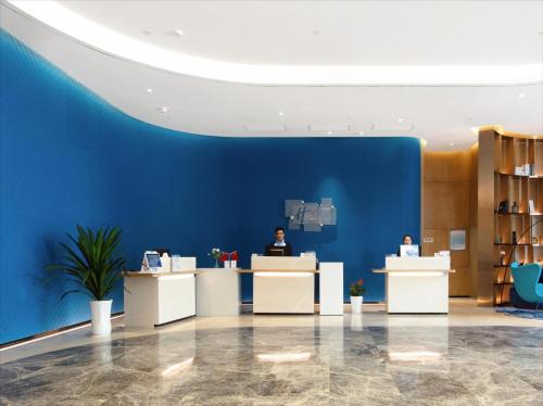 a man sitting at a counter in a blue room at Holiday Inn Express Zhoushan Dinghai by IHG in Zhoushan