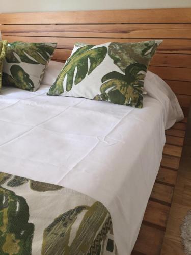 a bed with green and white sheets and pillows at Apartamento Smart in Buenos Aires