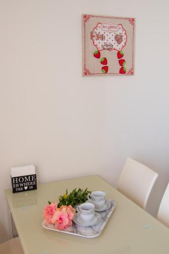 a table with two cups and a plate with flowers at Naxian Place in Agios Prokopios