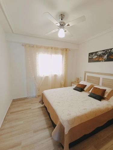 Schlafzimmer mit einem Bett und einem Deckenventilator in der Unterkunft Apartment in Torrevieja by the Beach in Torrevieja