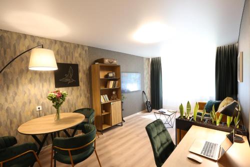 a living room with a table and chairs and a desk at Modern 2 Room Apartment - FREE PARKING - NETFLIX in Alytus