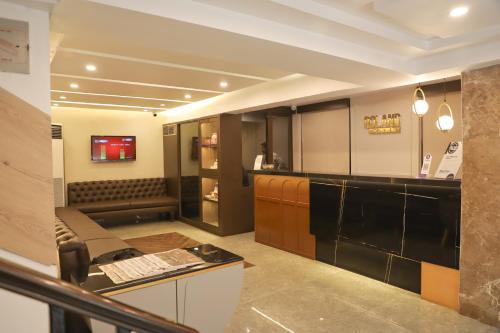 a room with a bar with a couch and a table at Roland Hotel in Kolkata