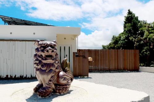une statue d'un lion debout devant une maison dans l'établissement Villa Piscine SESOKO -SEVEN Hotels and Resorts-, à Motobu