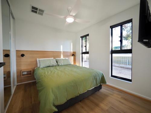 a bedroom with a bed and a ceiling fan at Ardrossan Caravan Park in Ardrossan