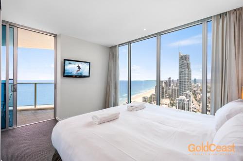 a bedroom with a large white bed and a large window at Gold Coast Private Apartments - H Residences, Surfers Paradise in Gold Coast