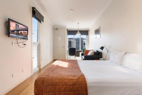 ein Schlafzimmer mit einem großen Bett und ein Wohnzimmer in der Unterkunft Smart Stayzzz Inns in Clermont