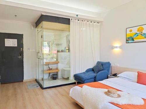 a bedroom with a bed and a blue chair at Sure I Do全景山宿 in Yangshuo