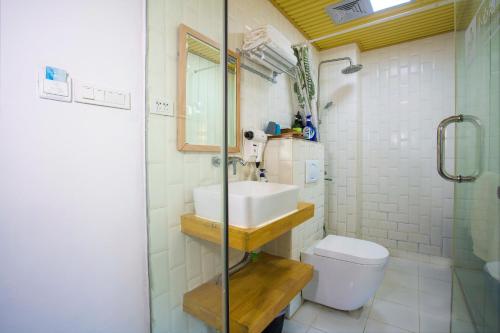 a bathroom with a sink and a toilet and a shower at Sure I Do全景山宿 in Yangshuo