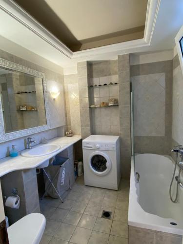 a bathroom with a sink and a washing machine at Atelié Γιούλη in Pefki