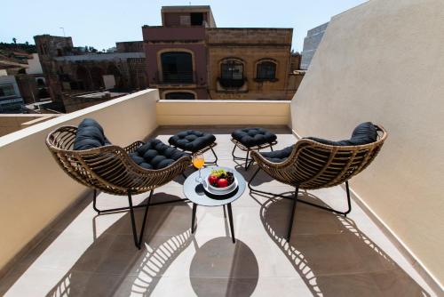 a balcony with two chairs and a table on a roof at City Stay B&B in Taʼ l-Imgħajjen