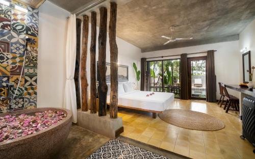 a bedroom with a white bed and a balcony at The Nature & Villas in Siem Reap