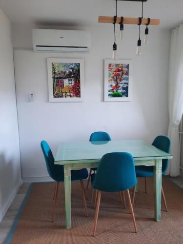 a dining room table with chairs and a blue table at Lala Boho apartment 2nd floor in Sarajevo