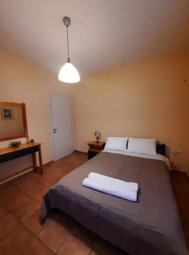 a bedroom with a bed with two white towels on it at Το πέτρινο της Δώρας in Kakóvatos