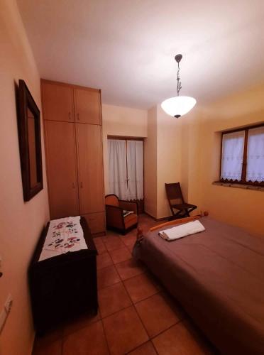 a bedroom with a bed and a chair in it at Το πέτρινο της Δώρας in Kakóvatos