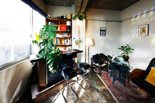 a living room with plants and a book shelf at FON-SU bed&breakfast in Osaka