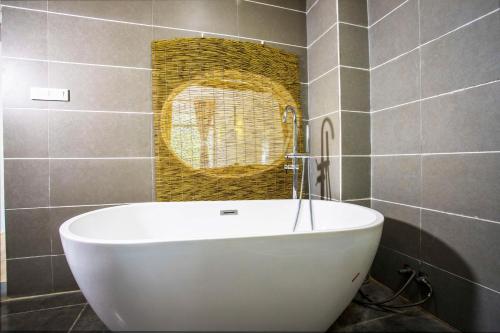 a white bath tub in a bathroom with a mirror at Sure I Do全景山宿 in Yangshuo