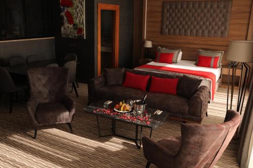 a living room with a bed and a couch and a table at Ramada by Wyndham Nigde in Nigde