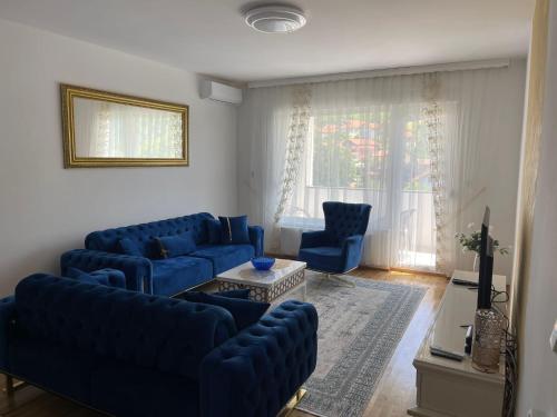 a living room with blue couches and a window at Apartment Visoko in Visoko