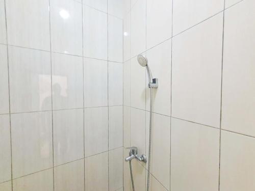 a shower with a shower head in a bathroom at Griya Shinta Syariah Solo Mitra RedDoorz in Bonorejo