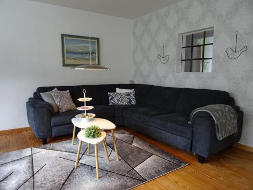 a living room with a black couch and a table at Bei Schütts in Janneby