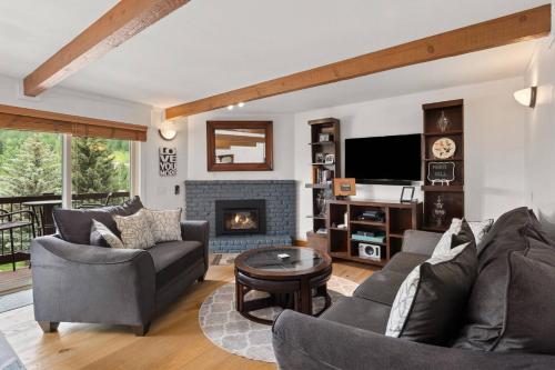 a living room with a couch and a fireplace at Woodbridge 21C in Snowmass Village