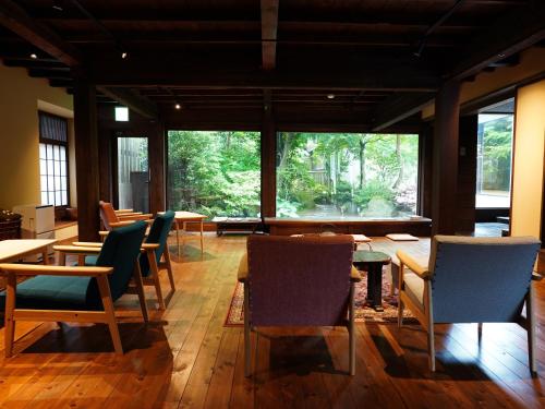 a room with tables and chairs and a large window at Hanakanzashi in Nihommatsu