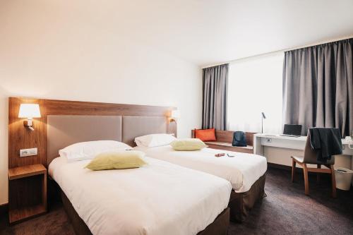 a hotel room with two beds and a desk at Campanile Metz Centre - Gare in Metz