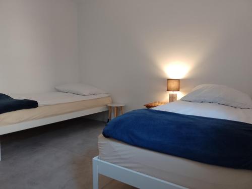 a bedroom with two beds and a lamp on a table at Guest House Ustka in Ustka