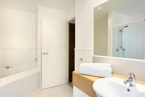 a bathroom with a sink and a tub and a mirror at 3 Hilltop Villas White Water Views from the Heart of Sunshine in Sunshine Beach