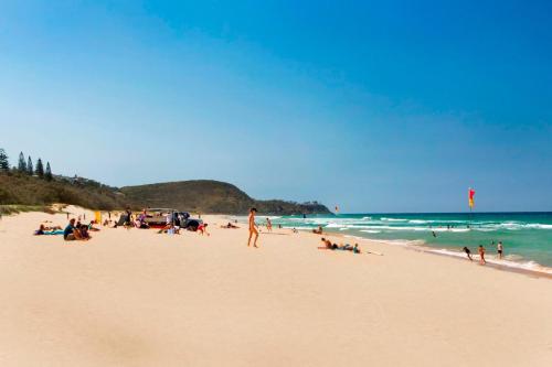 a group of people on a beach with the ocean at 3 Hilltop Villas White Water Views from the Heart of Sunshine in Sunshine Beach