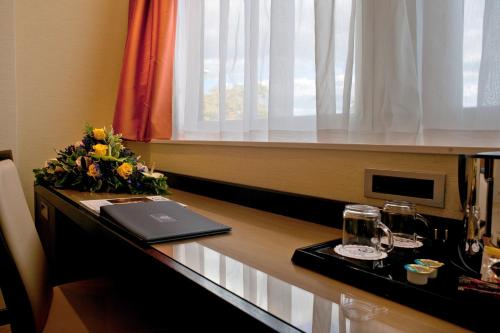 a desk with a laptop on it next to a window at Hotel San Pietro in Verona