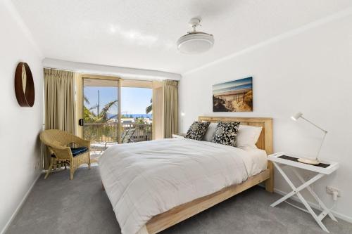 um quarto com uma cama grande e uma varanda em 5 Pacific Outlook Ocean View Apartment in Sunshine Beach em Sunshine Beach
