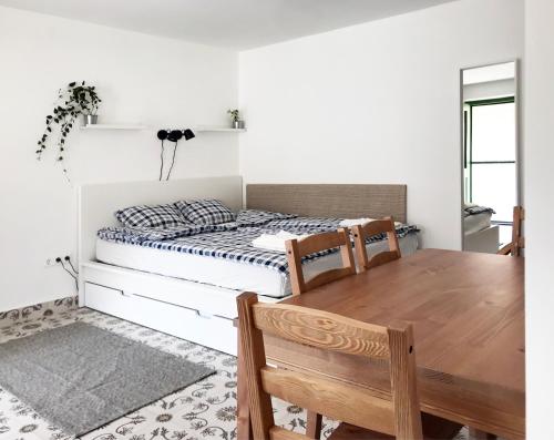 a bedroom with a bed and a wooden table at Nest Apartman in Balatonszárszó