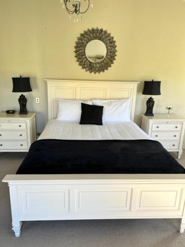 a bedroom with a large white bed and two night stands at Gibbston House Boutique B&B in Gibbston