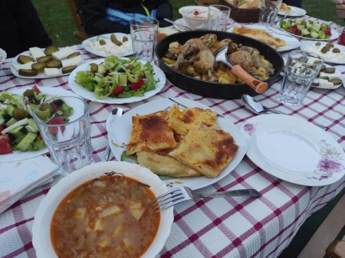 a table with plates of food and a bowl of soup at Bujtina Arlindi in Valbonë
